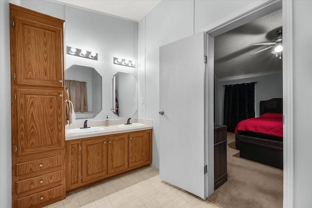 full bathroom with double vanity, a ceiling fan, a sink, and ensuite bath