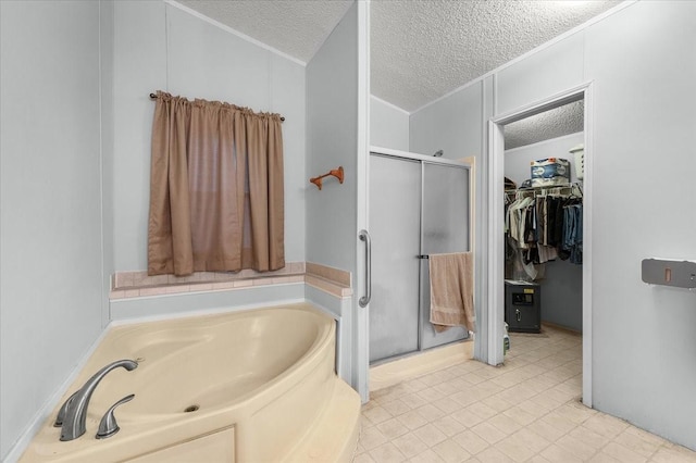 full bathroom featuring a bath, a stall shower, a textured ceiling, and a spacious closet