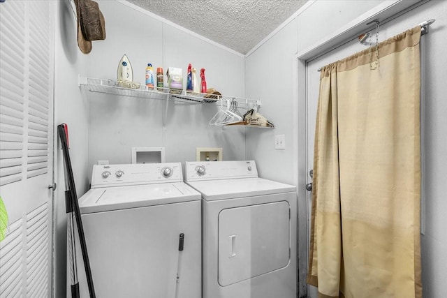 laundry area featuring crown molding, laundry area, a textured ceiling, and washer and dryer