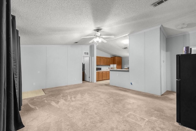 unfurnished living room with vaulted ceiling, a ceiling fan, light colored carpet, and visible vents