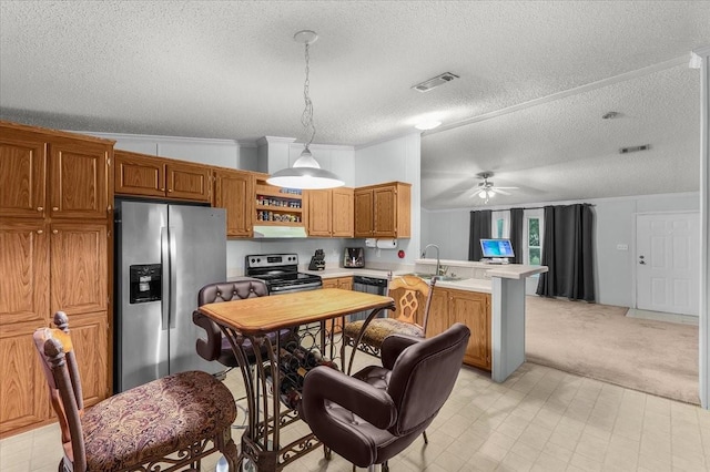 kitchen with visible vents, a peninsula, light carpet, light countertops, and stainless steel appliances
