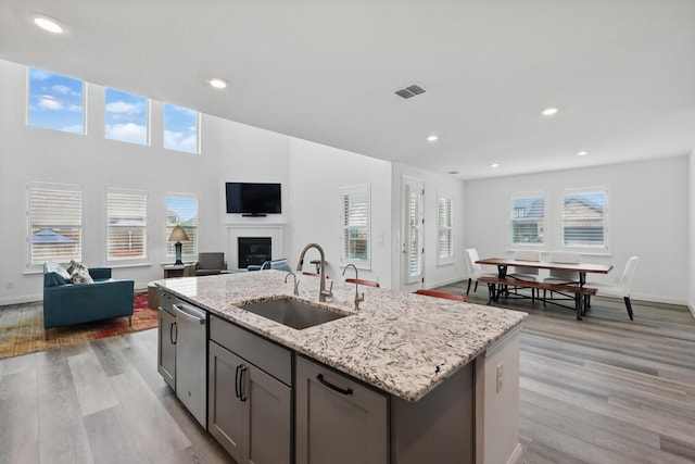 1210 Blazingstar Dr, Haslet, TX 76177 - kitchen featuring visible vents, open floor plan, light stone counters, a sink, and dishwasher
