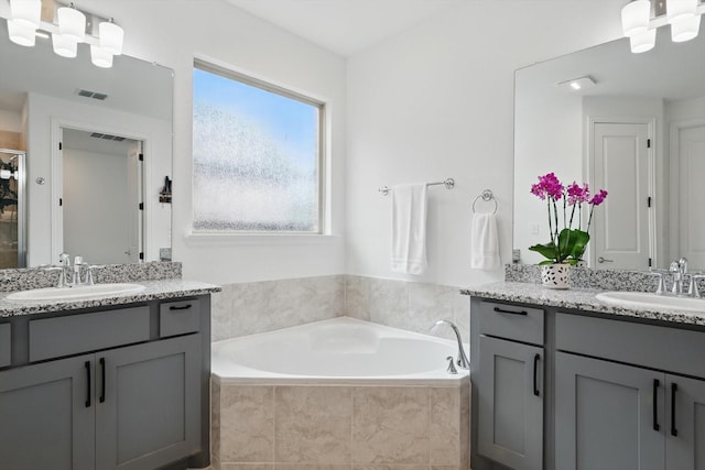 1210 Blazingstar Dr, Haslet, TX 76177 - bathroom with visible vents, two vanities, a sink, and a garden tub