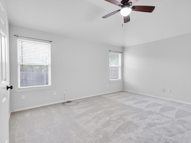 carpeted spare room featuring a ceiling fan and baseboards
