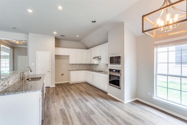 kitchen with plenty of natural light, a sink, stainless steel oven, and built in microwave