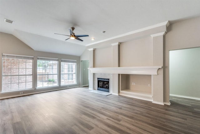 unfurnished living room with visible vents, wood finished floors, baseboards, ceiling fan, and a fireplace with flush hearth