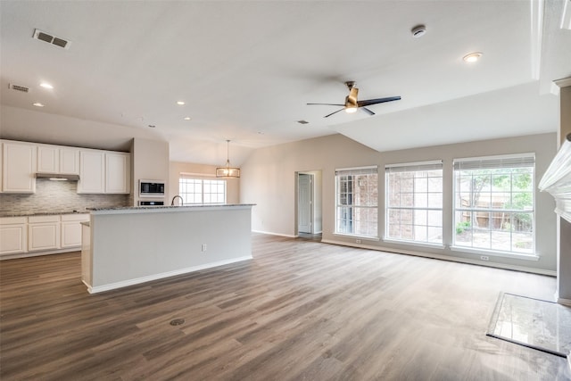 kitchen with plenty of natural light, visible vents, built in microwave, and lofted ceiling
