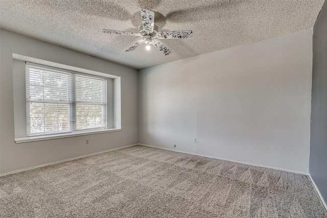 carpeted spare room with baseboards, ceiling fan, and a textured ceiling