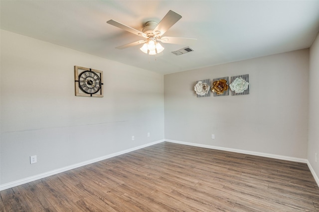 unfurnished room featuring baseboards, ceiling fan, wood finished floors, and visible vents