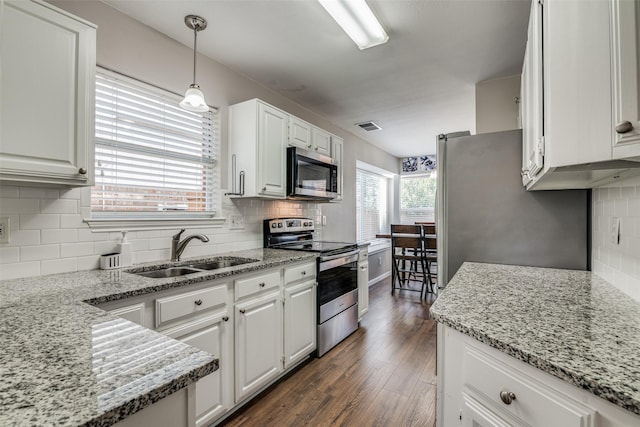 kitchen featuring a sink, appliances with stainless steel finishes, white cabinets, and decorative backsplash