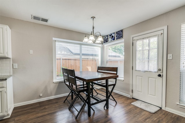 dining space featuring visible vents, dark wood finished floors, baseboards, and a notable chandelier