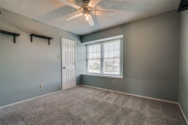 empty room with baseboards, carpet flooring, a textured ceiling, and a ceiling fan
