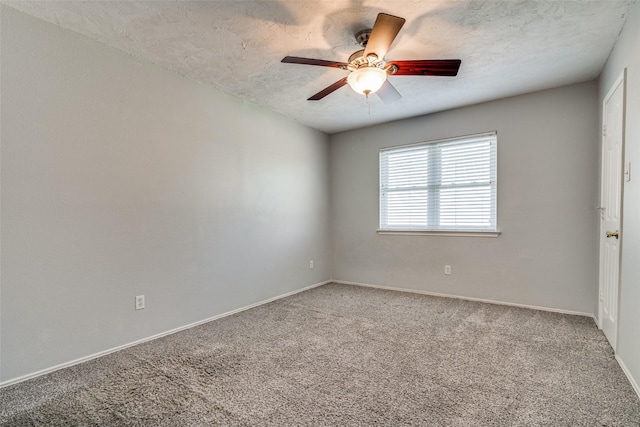 carpeted spare room with a textured ceiling, ceiling fan, and baseboards