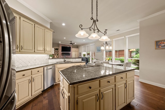 kitchen featuring appliances with stainless steel finishes, a sink, recessed lighting, cream cabinetry, and backsplash