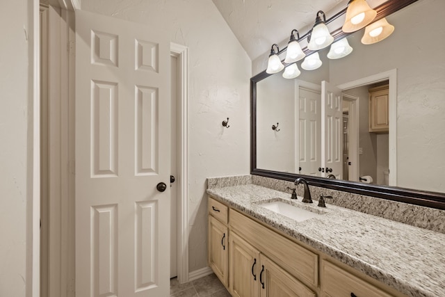 bathroom with vanity, tile patterned flooring, and toilet