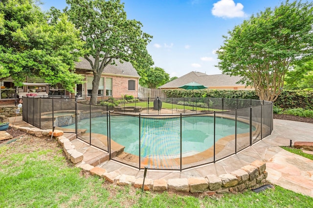 view of swimming pool with fence and a pool with connected hot tub