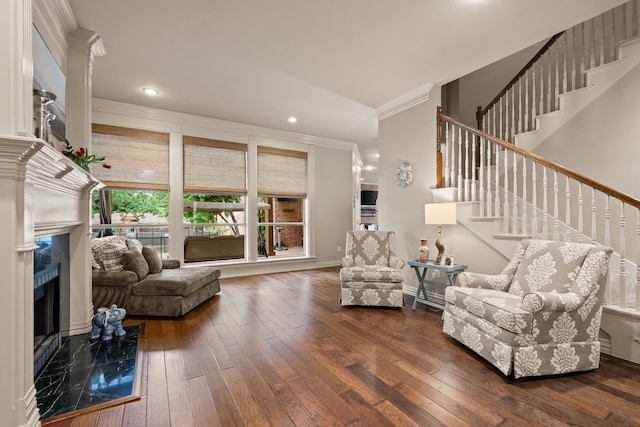 living room featuring wood-type flooring, ornamental molding, stairway, recessed lighting, and a premium fireplace