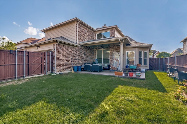 back of house with a fenced backyard, a gate, a patio, and brick siding