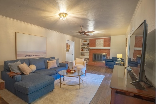 living area with crown molding, wood finished floors, and a fireplace