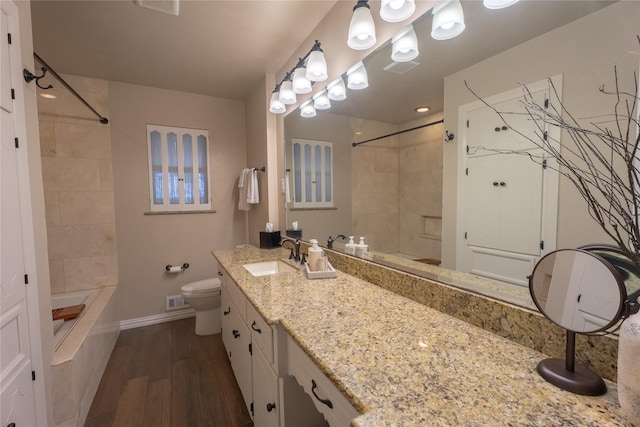 full bath featuring visible vents, vanity, wood finished floors, toilet, and baseboards