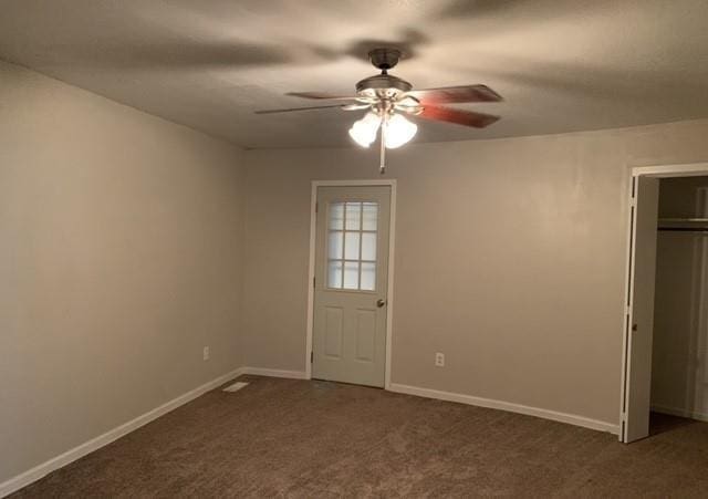 interior space with baseboards, carpet flooring, a ceiling fan, and a closet