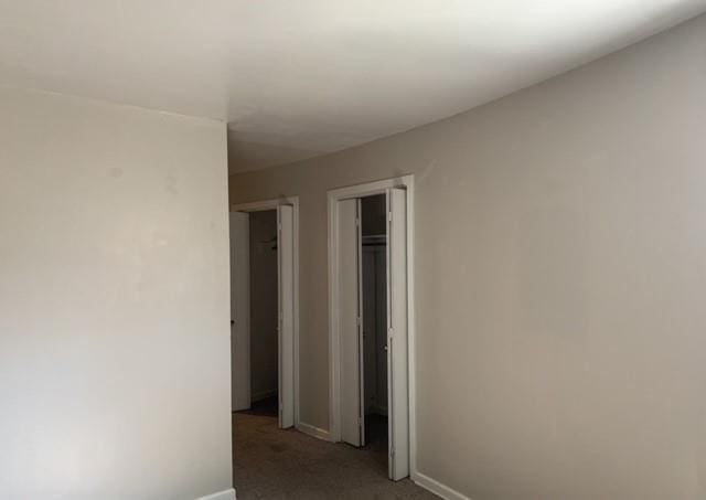 hallway featuring carpet flooring and baseboards