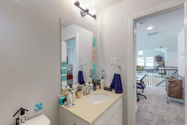 bathroom featuring toilet, visible vents, and vanity