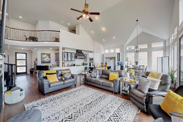 living area with recessed lighting, high vaulted ceiling, ceiling fan, and wood finished floors