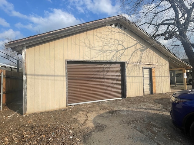 detached garage featuring fence