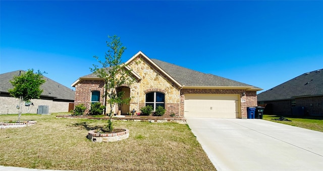 french country home featuring a garage, concrete driveway, a front yard, and brick siding