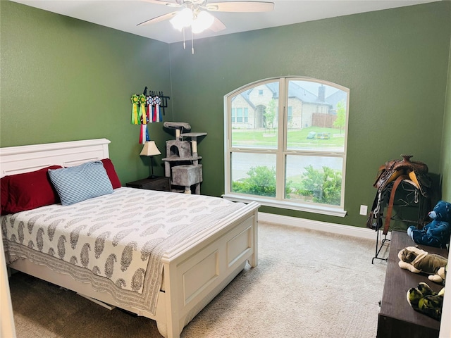 bedroom with baseboards, ceiling fan, and light carpet