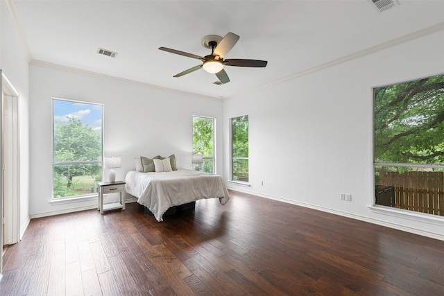 bedroom featuring crown molding, visible vents, multiple windows, and dark wood finished floors