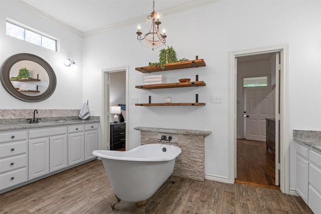 bathroom with vanity, a chandelier, a freestanding tub, wood finished floors, and ornamental molding