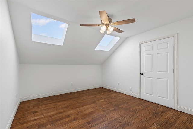 bonus room with baseboards, a ceiling fan, wood finished floors, and vaulted ceiling with skylight