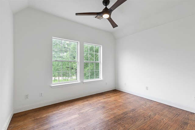 empty room with a ceiling fan, baseboards, vaulted ceiling, and wood finished floors