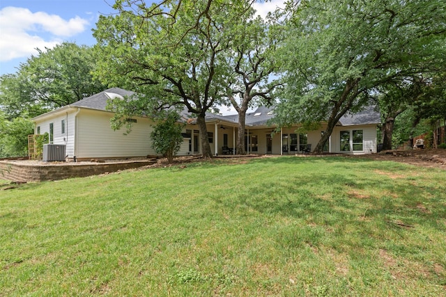 back of property featuring a lawn and central air condition unit
