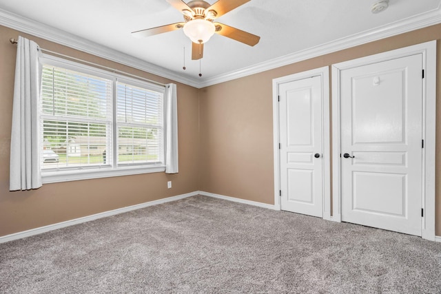 unfurnished bedroom with ceiling fan, carpet floors, baseboards, ornamental molding, and a closet