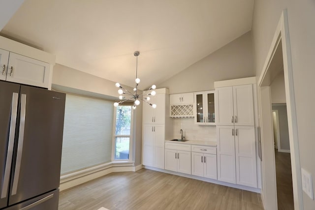 3509 Arbuckle Dr, Plano, TX 75075 - kitchen with freestanding refrigerator, light wood-type flooring, white cabinetry, tasteful backsplash, and a sink