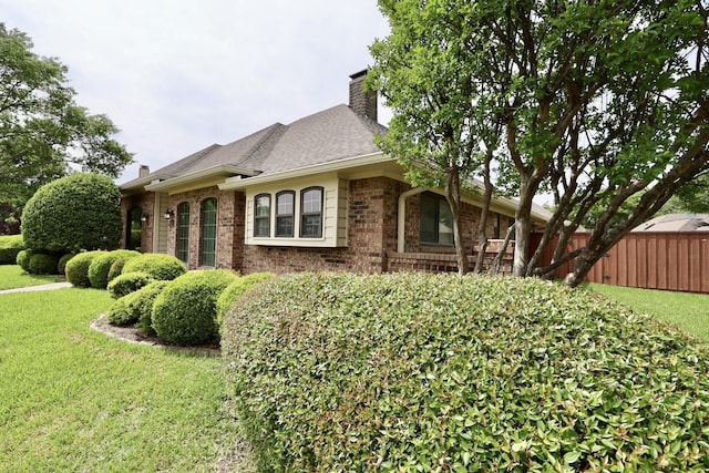 3509 Arbuckle Dr, Plano, TX 75075 - view of property exterior with brick siding, a lawn, fence, and a chimney
