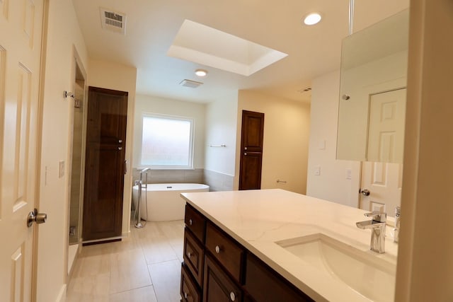 3509 Arbuckle Dr, Plano, TX 75075 - full bath with visible vents, a freestanding bath, a skylight, tile patterned floors, and vanity