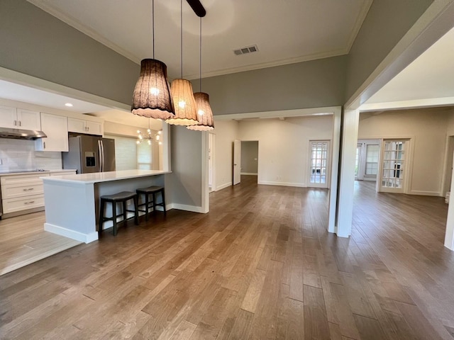 3509 Arbuckle Dr, Plano, TX 75075 - kitchen with crown molding, visible vents, stainless steel fridge, light countertops, and white cabinets