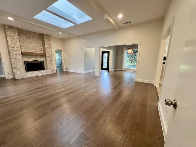 3509 Arbuckle Dr, Plano, TX 75075 - unfurnished living room featuring a skylight, visible vents, dark wood-style floors, and a fireplace