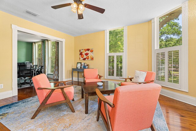 1009 N Pacific, Mineola, TX 75773 - living area with wood-type flooring, ceiling fan, baseboards, and a textured ceiling