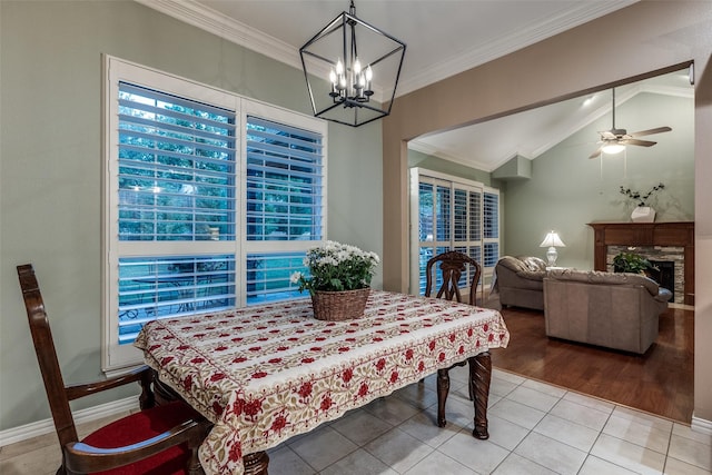 3788 Zion Rd, Garland, TX 75043 - dining space with tile patterned flooring, a fireplace, ceiling fan with notable chandelier, lofted ceiling, and ornamental molding
