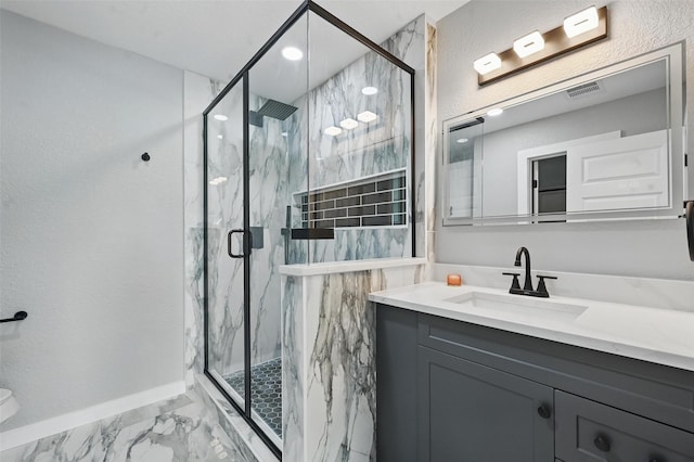 full bath with baseboards, vanity, a marble finish shower, and marble finish floor