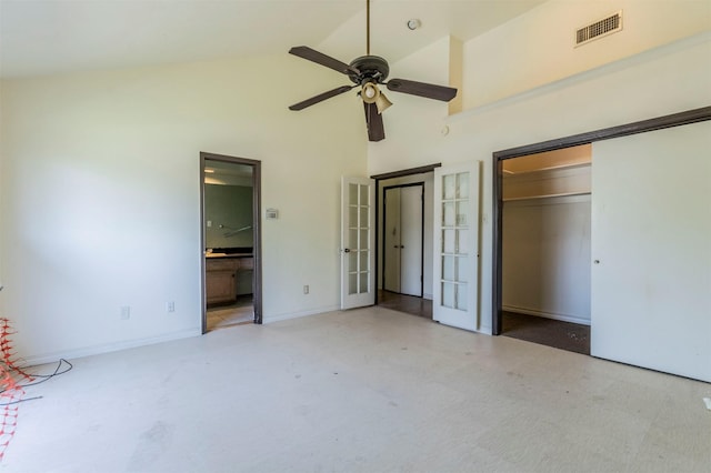 unfurnished bedroom featuring high vaulted ceiling, french doors, ensuite bathroom, visible vents, and a closet