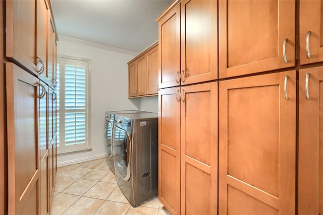laundry room with cabinet space, crown molding, light tile patterned flooring, separate washer and dryer, and baseboards