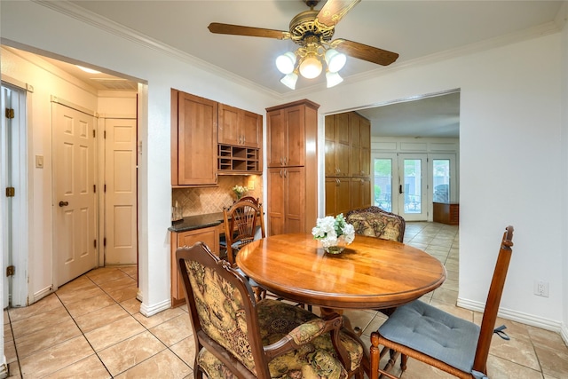 dining area with baseboards, ceiling fan, ornamental molding, and light tile patterned flooring