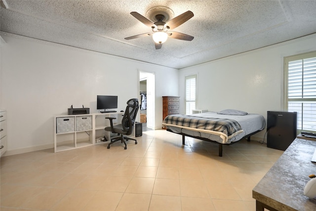 bedroom with light tile patterned floors, ceiling fan, and a textured ceiling