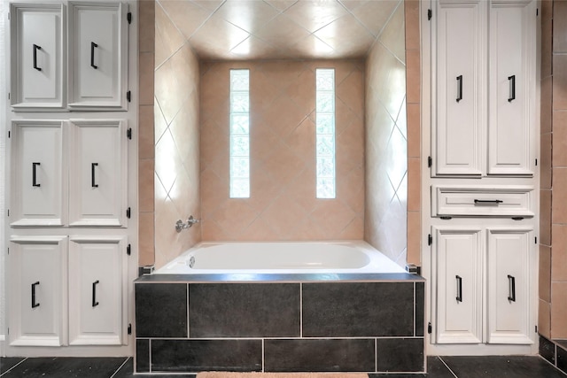 full bath with tiled bath and tile walls